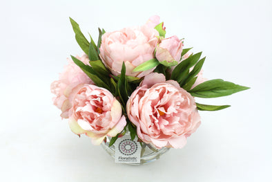 Pink artificial Peony flowers arranged in clear fishbowl vase with artificial water